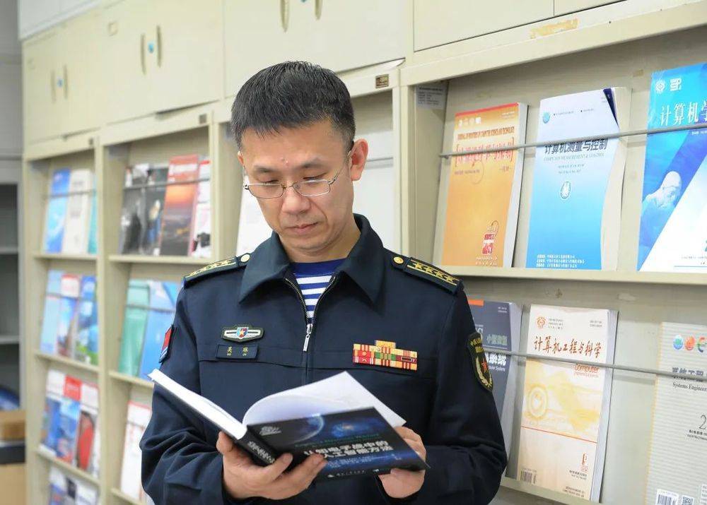他是国防大学教授，他的办公桌上摆放着三个电脑显示屏……